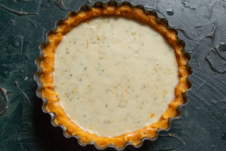 Pouring the Filling into the Pastry Case Pouring the savory onion and egg filling into the unbaked pastry shell.