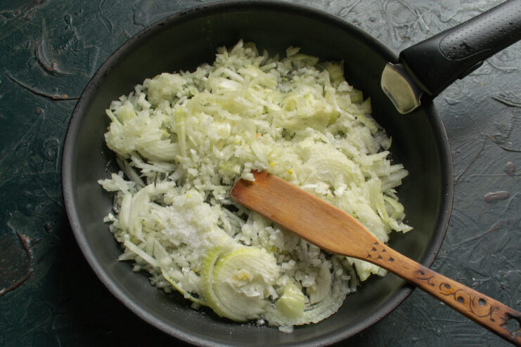 Finely Dicing Onions for the Filling A pile of finely chopped yellow onions on a cutting board.