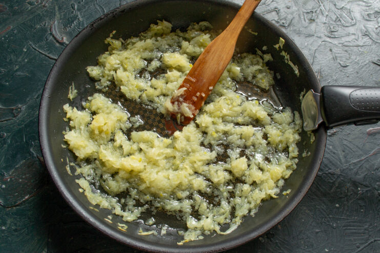 Caramelizing Onions for a Rich Quiche Filling Chopped onions being sautéed in a pan until golden and caramelized.