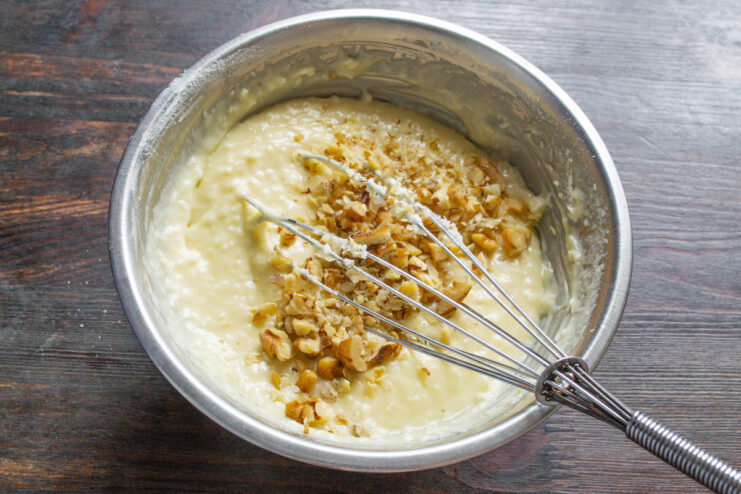 Adding chopped walnuts for extra crunch and flavor Adding chopped walnuts to the coconut cupcake batter.