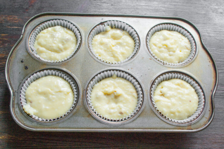 Preparing the muffin tin with paper liners for baking A muffin tin with colorful paper cupcake liners placed in each cup.