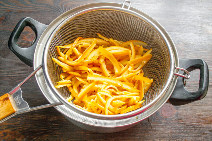 Softened Orange Peels Ready for the Sugar Syrup Soft, boiled orange peels drained in a colander, ready for the next step.