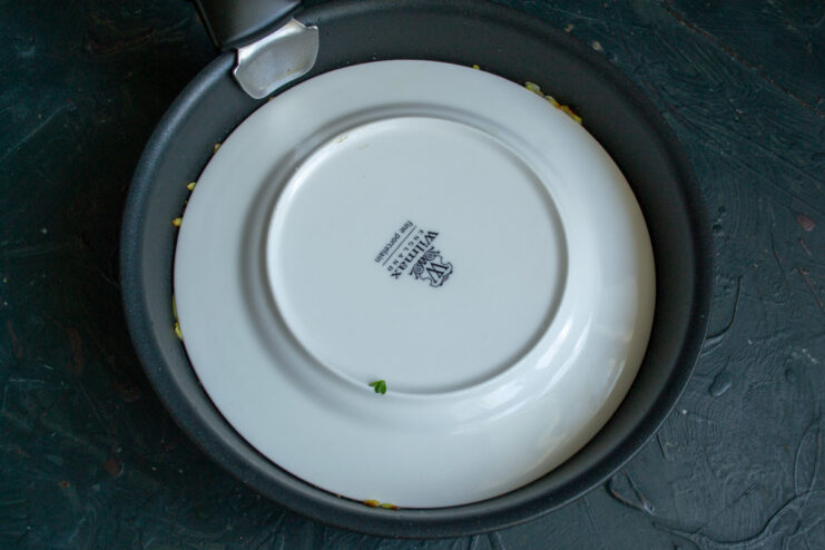 Frying on high heat helps to create a perfectly crispy crust on the potato pancake. A large potato pancake frying in a skillet, turning golden brown on one side.