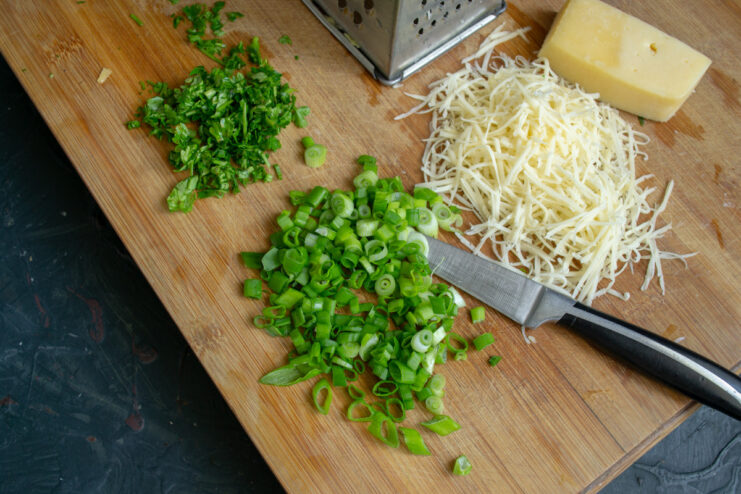 Fresh green onions will add a bright, fresh flavor to the dish. Finely chopping fresh green onions on a cutting board.