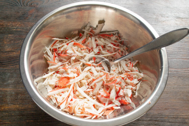 Starting the Patty Mixture A deep glass bowl filled with grated crab sticks.