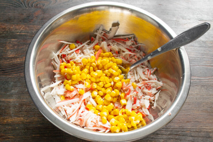 Draining Canned Corn for the Recipe Canned corn being drained in a fine-mesh sieve over a bowl.