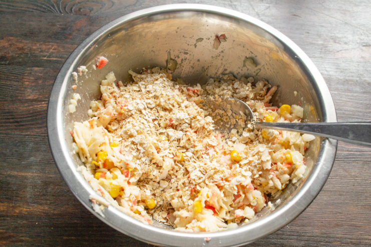 Mixing and Resting the Patty Dough The crab stick patty mixture being thoroughly combined in a glass bowl.