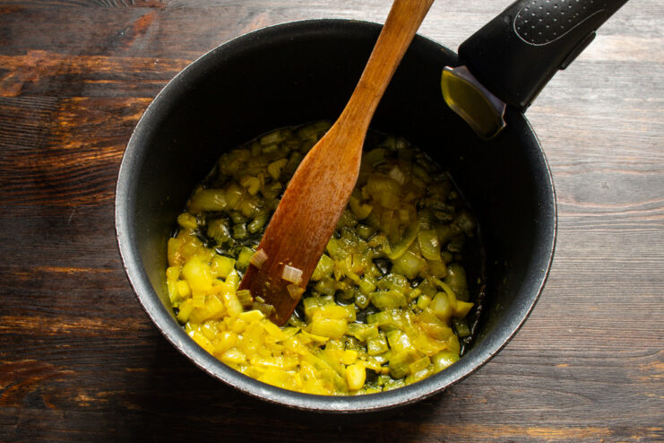 Sautéing onions with turmeric to build the soup's flavor base. Chopped onions being sautéed in a pan until soft and translucent.
