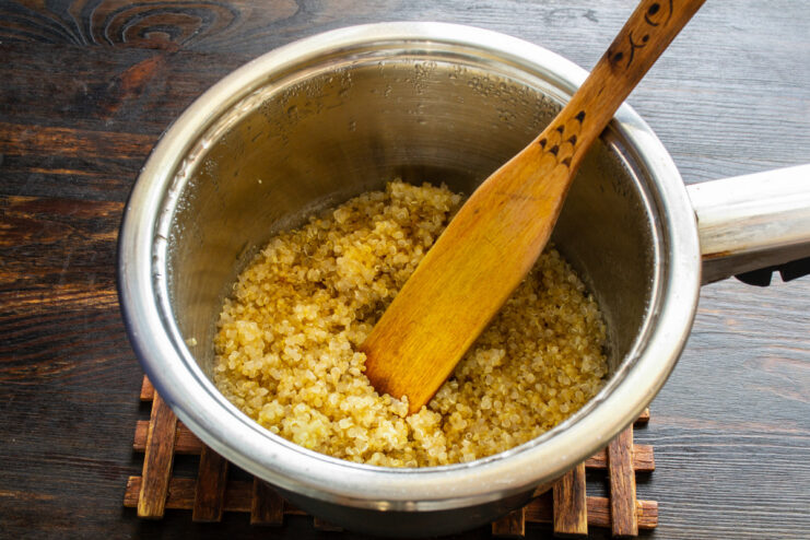 Quinoa cooking in a saucepan with water.