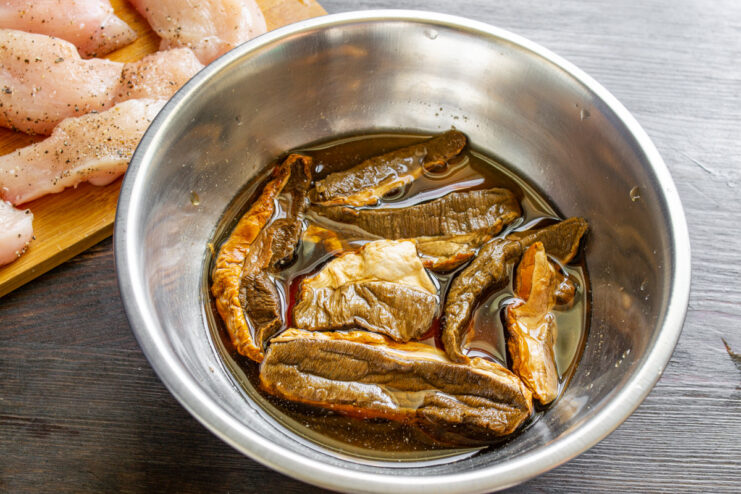 Soaking Dried Wild Mushrooms to Rehydrate Them Dried wild mushrooms soaking in a bowl of water.