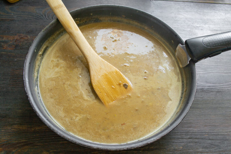 Making the Creamy Mushroom Sauce Cream being poured into a pan with mushrooms and onions to make the sauce.