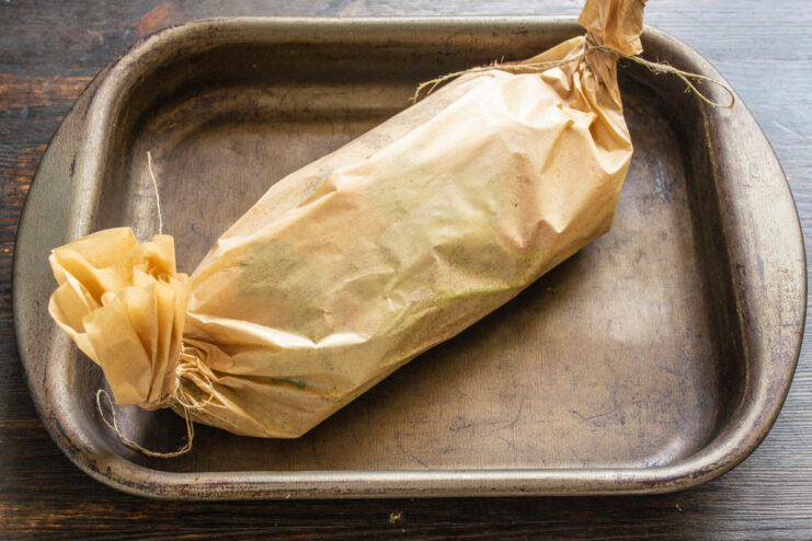 Preheating the Oven to the Correct Temperature for Baking A sealed parchment envelope with chicken inside, ready to be placed in the oven.