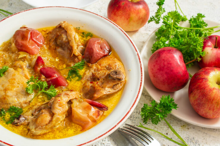 A serving dish with honey-glazed chicken thighs baked in a roasting bag, garnished with parsley.