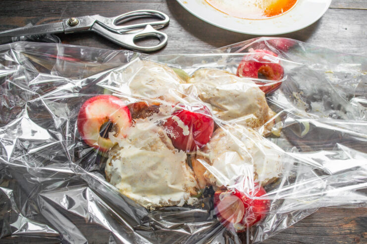 Step 7: Adding Apples and Marinade for Extra Flavor Cored apples and remaining marinade being added to the roasting bag with chicken.