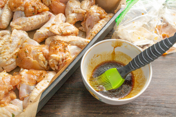 Preparing the Glaze for Basting The leftover honey-soy marinade being collected in a small white bowl for glazing.