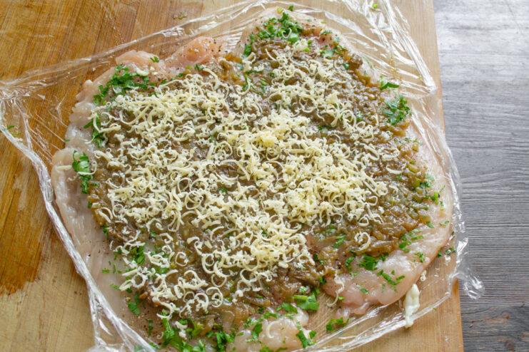 Adding a Layer of Cheese for a Melty Roulade Center Grated cheese being sprinkled over the mushroom filling on a chicken breast.