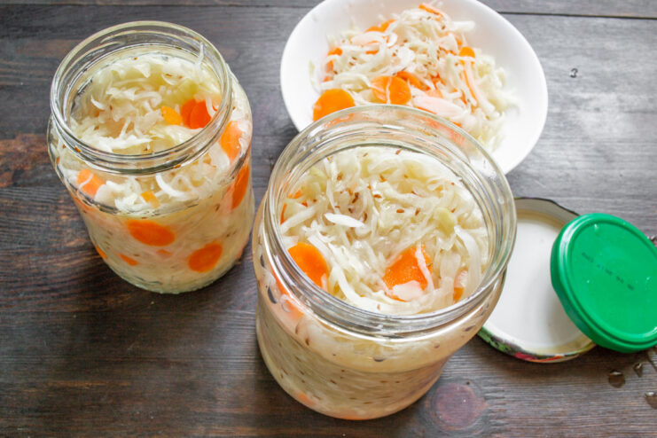 Packing Your Finished Sauerkraut into Jars for Storage Transferring finished sauerkraut from a large pot into a glass jar.