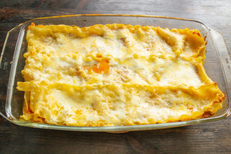 Baking the lasagna until golden and bubbly Placing the baking dish with lasagna into a hot oven.