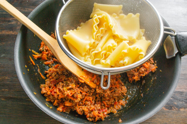 Cooking the lasagna pasta sheets until al dente Lasagna pasta sheets being cooked in a pot of boiling water.
