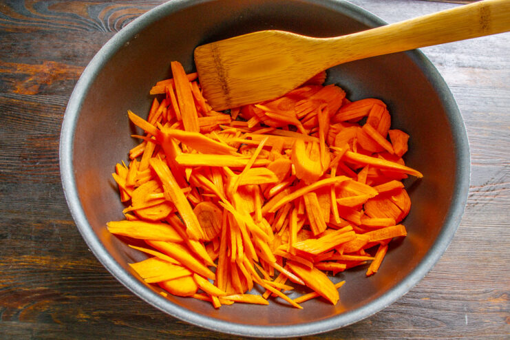 Step 1: Preparing the Carrots for Lecho A pile of bright orange julienned carrots on a cutting board, ready for the lecho.