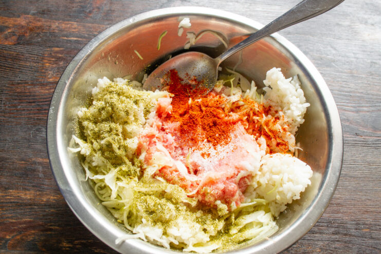 Seasoning the Lazy Cabbage Roll Mixture Spices, including paprika and dill, being added to the meat and cabbage mixture.