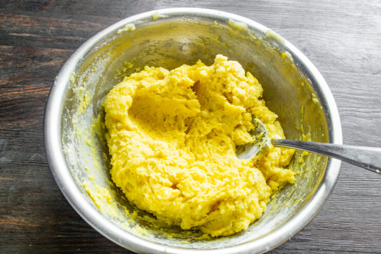 Letting the potato dough rest to develop its texture. A smooth ball of yellow potato dough resting in a glass bowl.