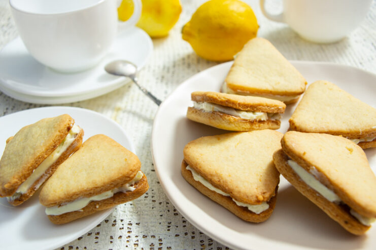 A plate of finished lemon cookies with lemon cream, stacked and ready to serve.