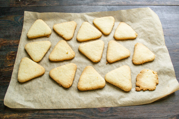 Golden-brown lemon cookies fresh out of the oven on a baking sheet.