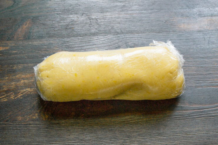 A ball of cookie dough wrapped in plastic wrap, ready for chilling.