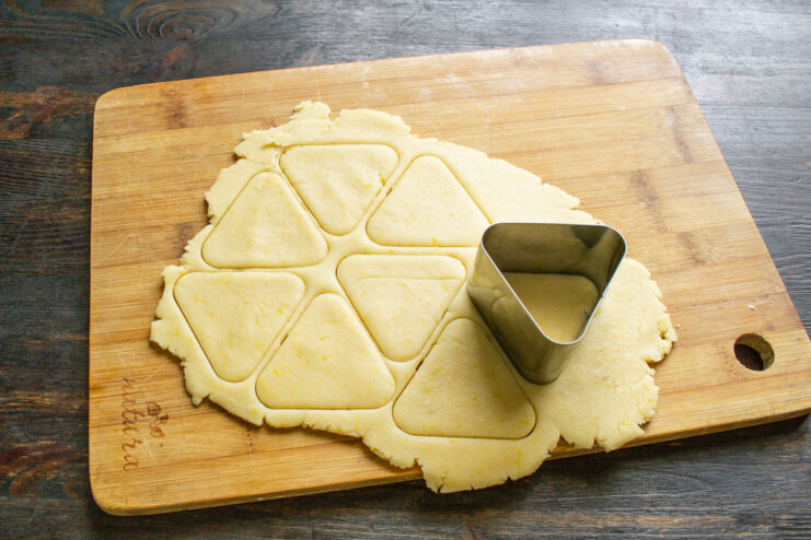 Using a cookie cutter to cut shapes from the rolled-out dough.
