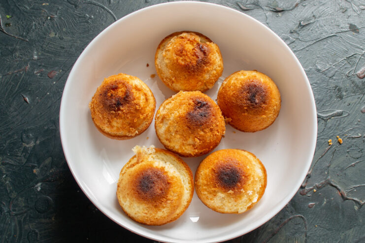 Freshly Baked Lemon Buns Golden brown lemon buns just removed from their baking molds, cooling on a surface.