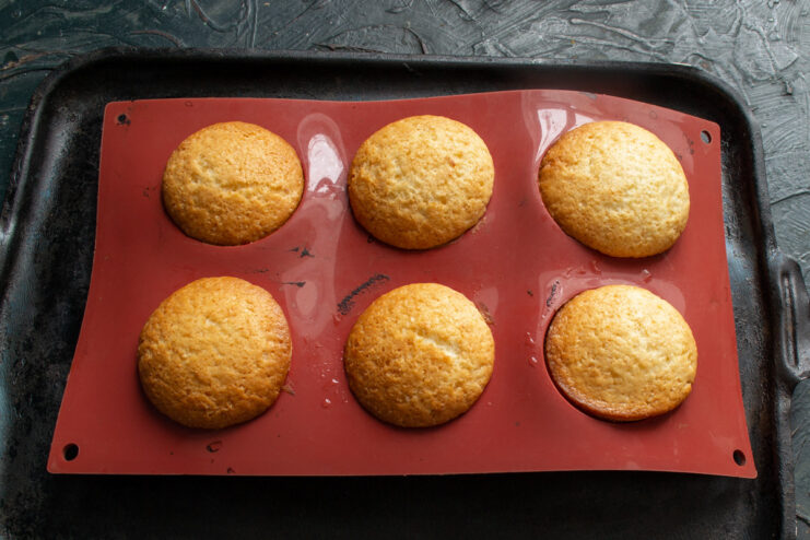 Baking the Lemon Buns Until Golden A baking pan with lemon buns inside an oven, baking to a golden brown color.