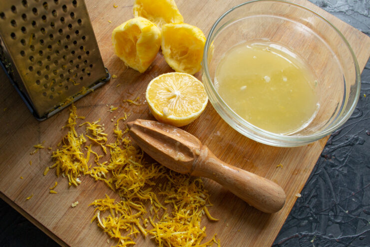 Tip: Use Juicy Lemons to Get the Right Amount of Juice for Your Curd Two whole lemons and a glass of freshly squeezed lemon juice on a wooden surface.