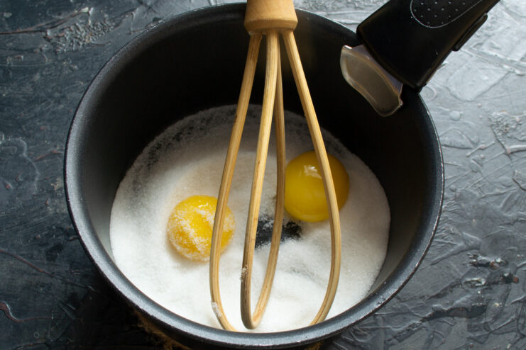 Starting the Lemon Curd Base with Sugar and Salt in a Saucepan Pouring sugar and salt into a heavy-bottomed saucepan to start the lemon curd.