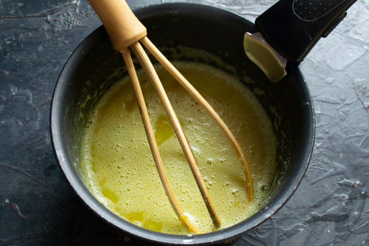 Gently Heating the Curd Mixture While Whisking Constantly Whisking the lemon curd mixture in a saucepan over low heat.