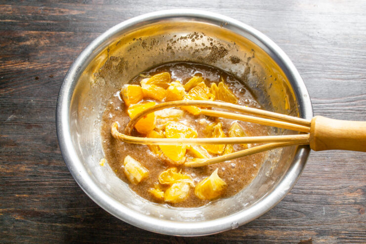 Step 4: Incorporating fresh chopped orange into the batter Adding pieces of fresh orange and juice to the muffin batter.