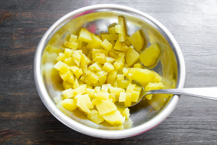 Dicing Boiled Potatoes for Salad Close-up of diced potatoes boiled in their jackets in a glass bowl for the salad.