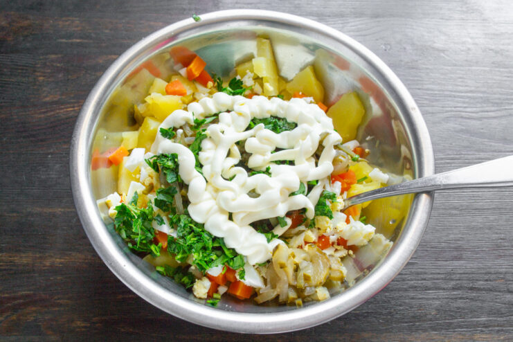 Creating the Creamy Dressing with Mayonnaise Adding a spoonful of creamy Provansal mayonnaise to the bowl of salad ingredients.