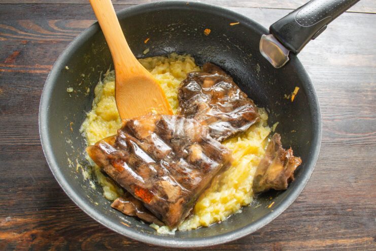 Adding Earthy Wild Mushrooms to the Caramelized Onions Frozen wild mushrooms being added to the pan of caramelized onions.