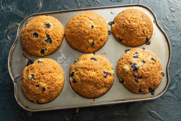 Bake until the muffins are golden brown and perfectly risen Blueberry muffins baking in the oven, turning golden brown.
