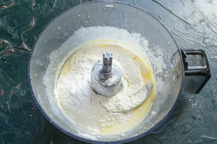 Combining dry and wet ingredients for the perfect muffin batter consistency Adding flour and baking powder to the wet ingredients in a food processor.