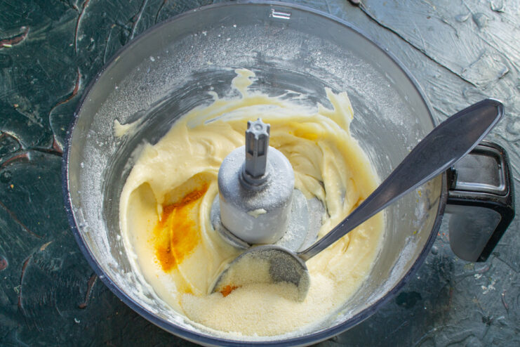 A touch of semolina and turmeric adds texture and a beautiful golden color Adding semolina and a pinch of turmeric to the muffin batter in a bowl.
