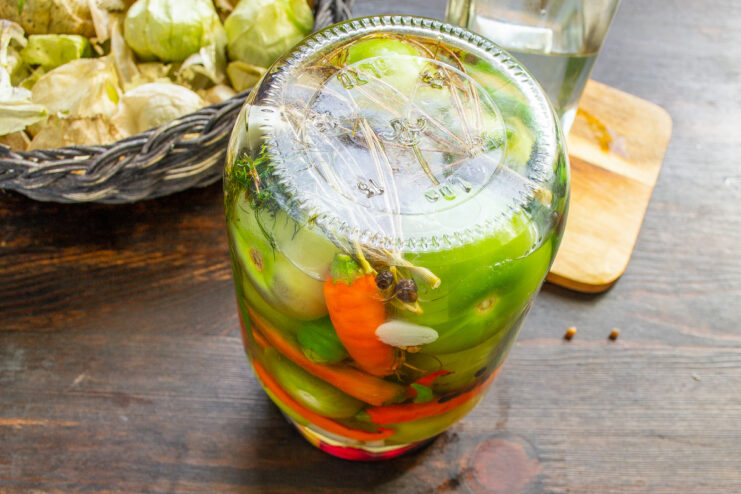 Properly stored marinated physalis will last all winter long. A finished, sealed jar of marinated physalis with chili and garlic, ready for storage.