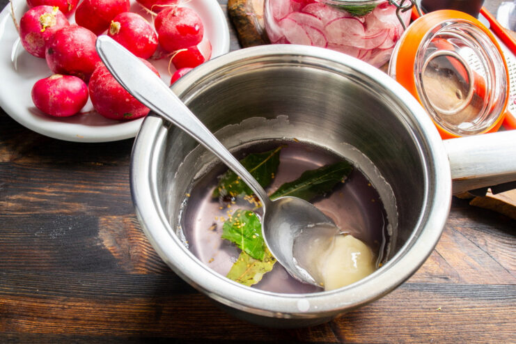 Creating the Sweet and Tangy Marinade Base Honey being drizzled into a bowl containing the pickling marinade and spices.