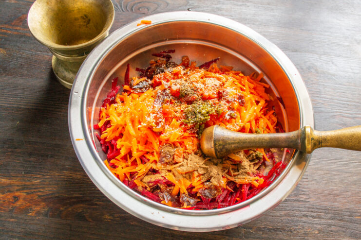 Freshly ground toasted cumin seeds add an incredible depth of aroma and flavor. Adding freshly ground cumin from a mortar into the salad bowl.