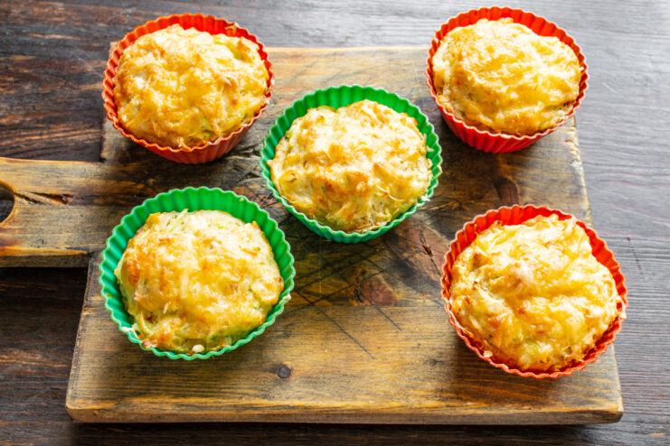 Serving Hot Mini Zucchini and Cheese Casseroles Freshly baked mini zucchini and cheese casseroles on a plate, served hot.