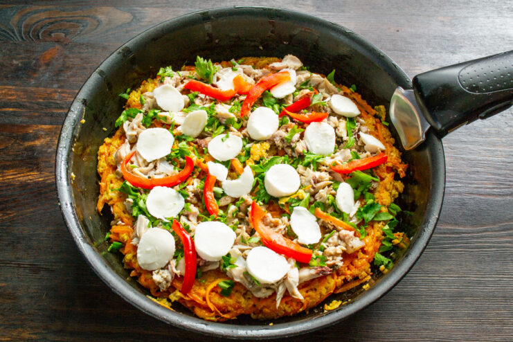 Adding Colorful Bell Peppers Arranging strips of red bell pepper on top of the mozzarella on the carrot pizza.