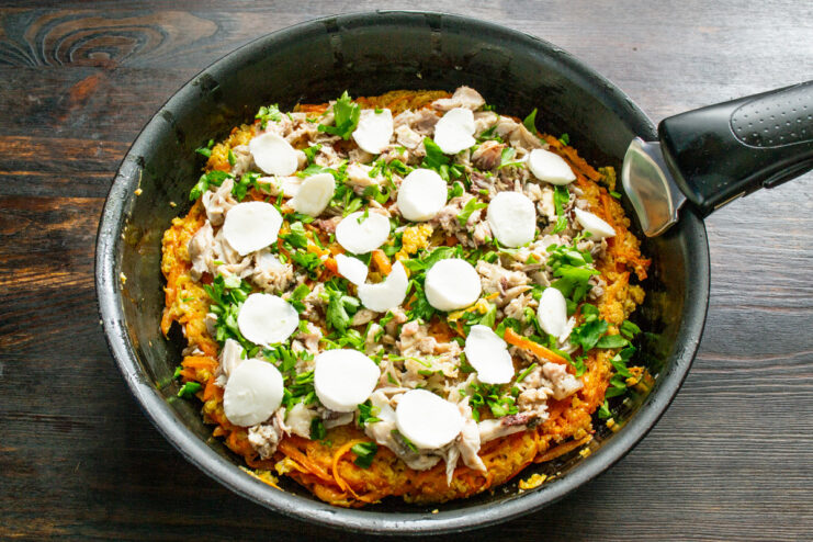 Topping the Pizza with Mozzarella Cheese Placing thin slices of mini mozzarella balls on the carrot pizza.