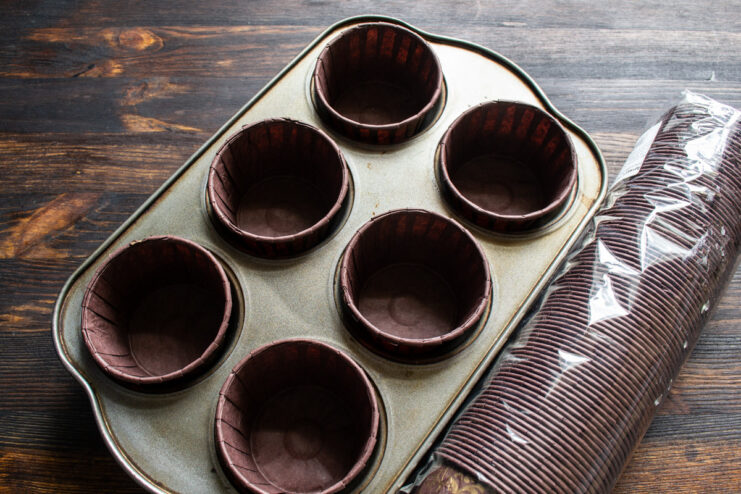 Preparing the Muffin Tin with Paper Liners A metal muffin tin with colorful paper liners placed in each cup, ready for batter.