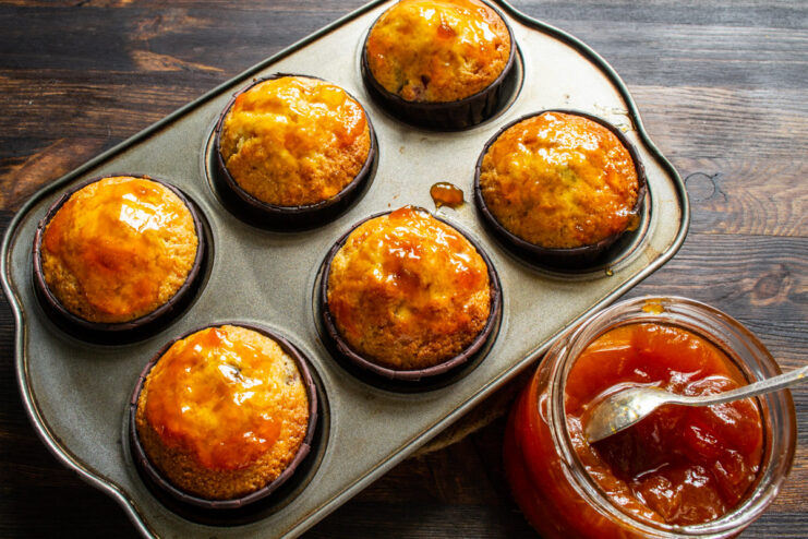 Glazing Muffins with Apricot Jam A small bowl of apricot jam next to freshly baked muffins, ready for glazing.